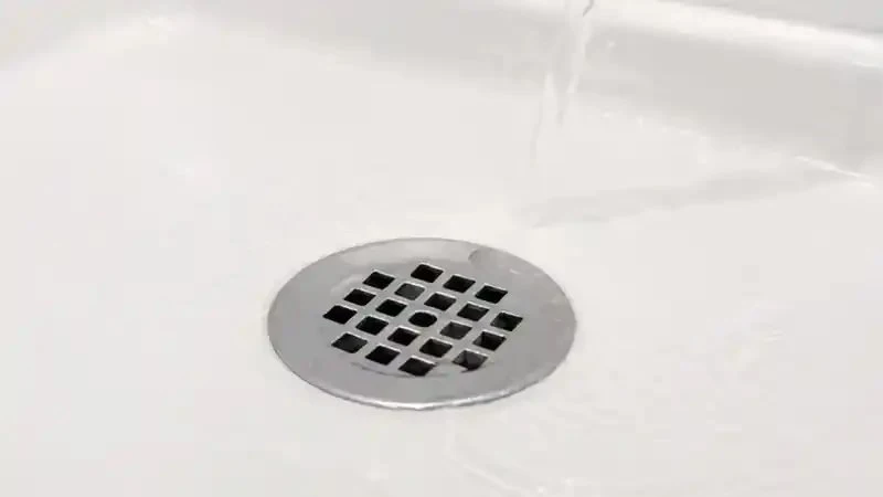 Clean residential shower drain with clear water flowing